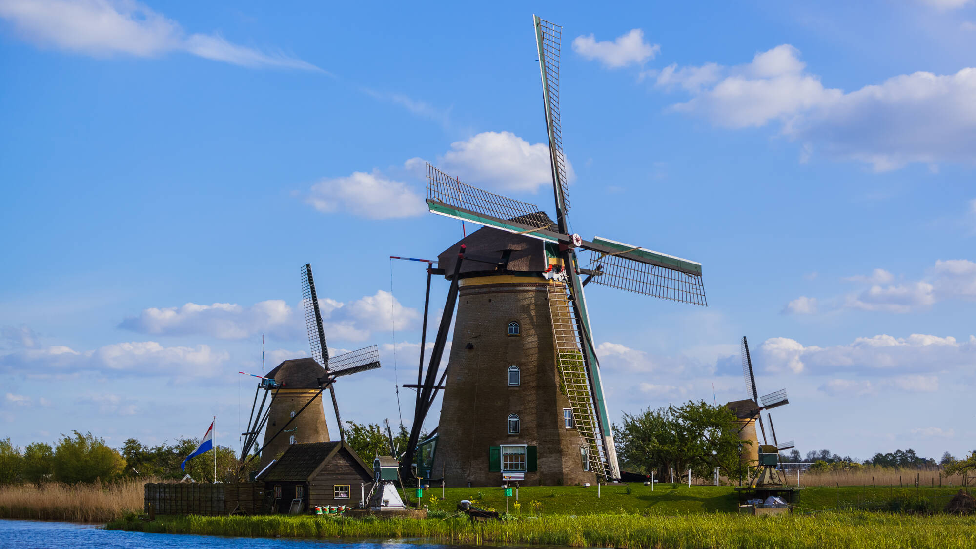 Un moulin à vent au bord d'une rivière. La plus ancienne utilisation mécanique de l'éolien.