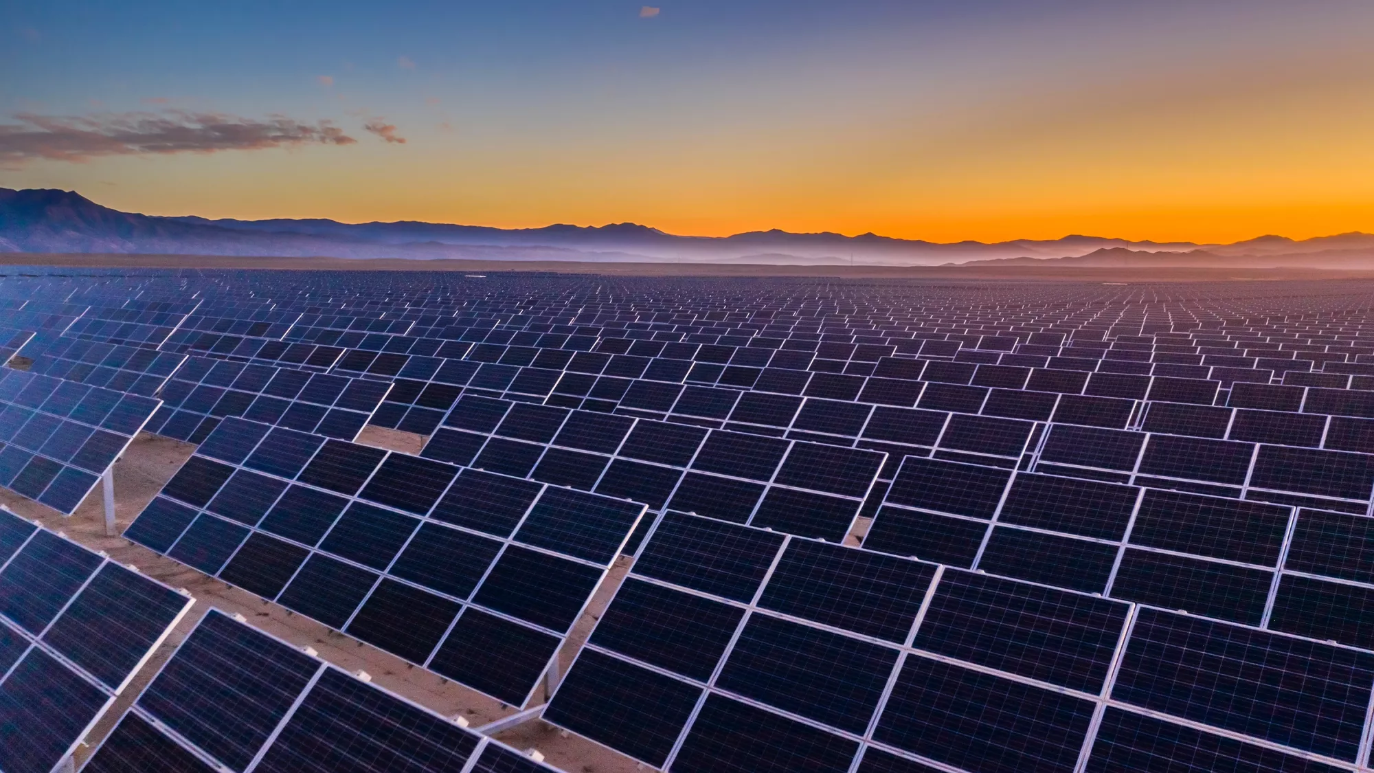 Une centrale solaire avec un champ de panneaux photovoltaïques inclinés.