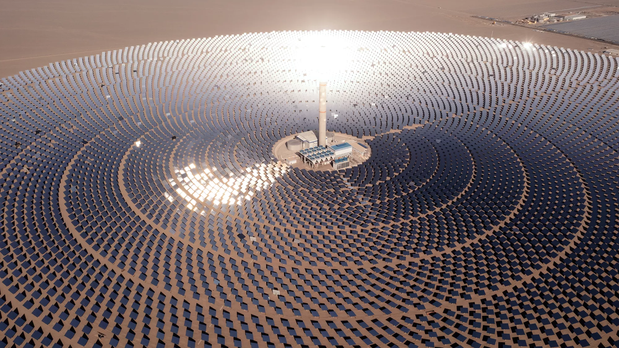 Une centrale solaire à concentration avec une tour contenant des sels liquides chauffés par un cercle d'héliostats.