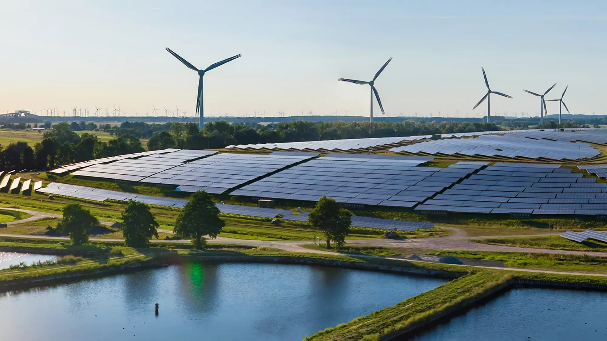 Champ d'éoliennes et panneaux solaires, une forte progression souhaitée pour diversifier le mix énergétique en Suisse. 