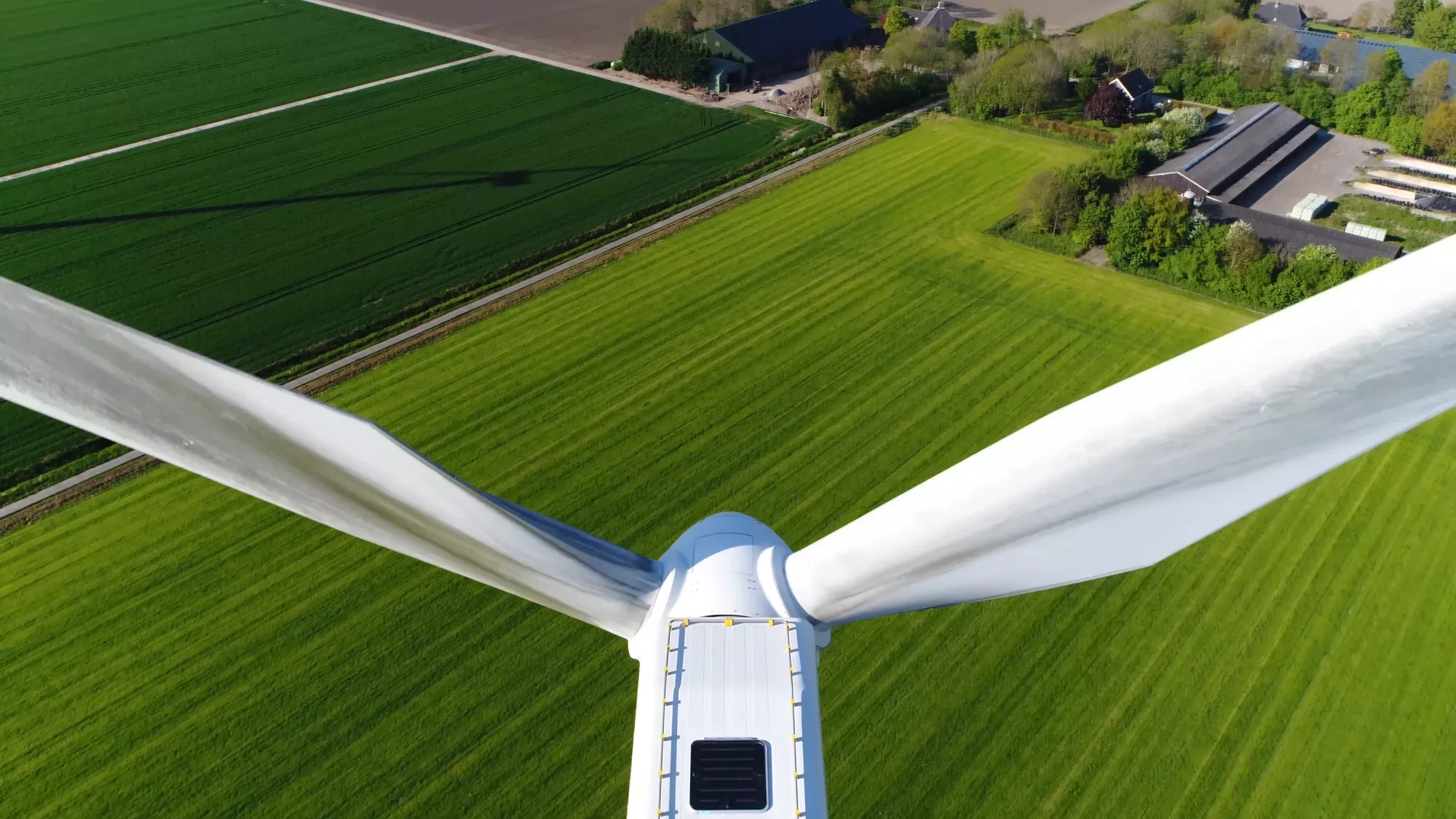 Une grande éolienne vue depuis le sommet de son rotor. Une composante indispensable du mix des énergies renouvelables en Suisse.