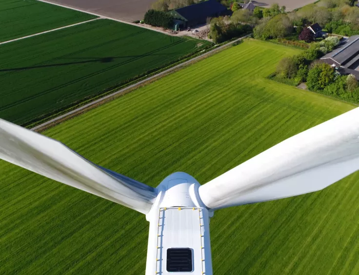 Une grande éolienne vue depuis le sommet de son rotor. Une composante indispensable du mix des énergies renouvelables en Suisse. 